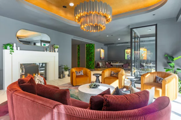Stylish lounge with curved seating, gold ceiling, and modern chandelier.