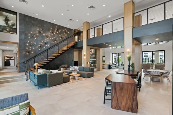 Spacious lobby with modern seating, staircase, and decorative lighting.