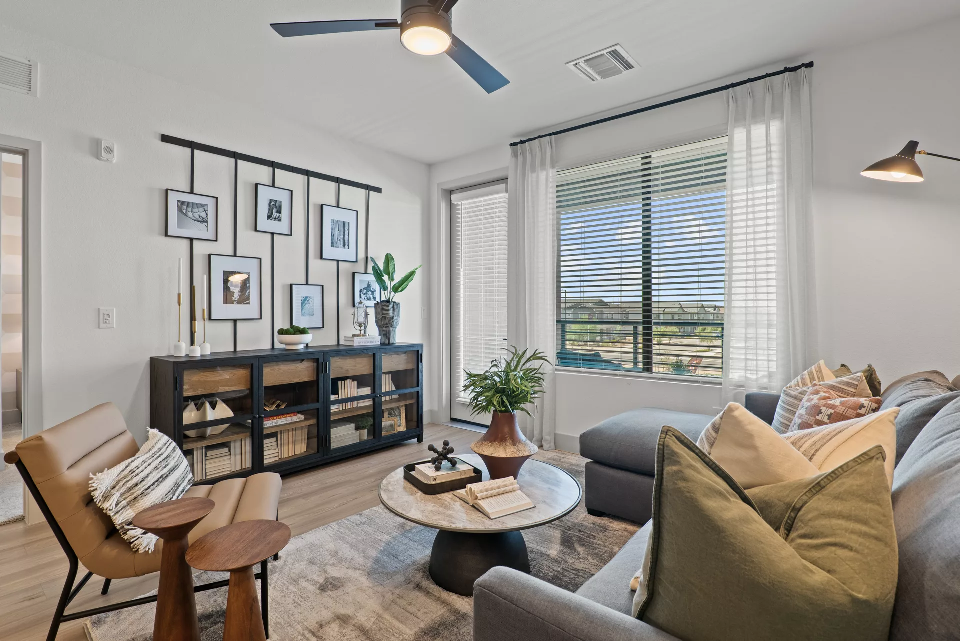 Modern living room with large windows, sofa, and decorative wall art.