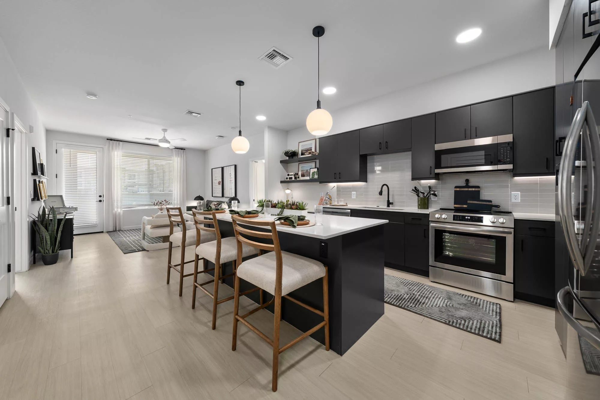 Modern kitchen with black cabinets and island seating for four.