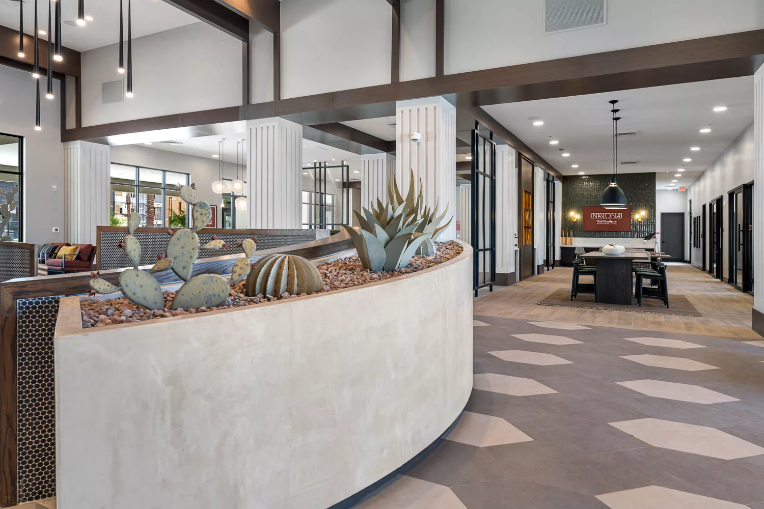 Modern lobby with desert-themed planter and geometric flooring.