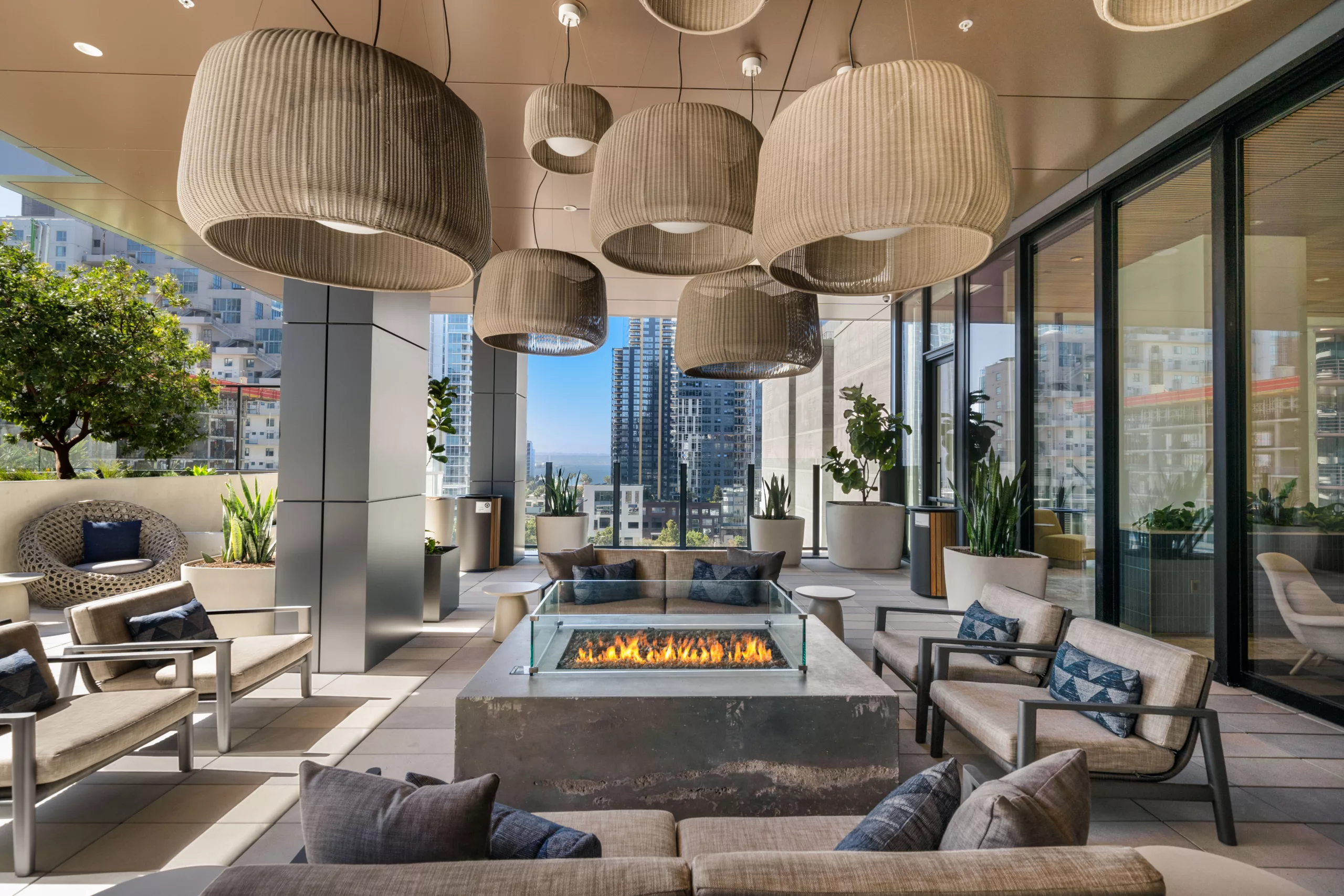 Covered terrace with firepit, seating, and hanging lights