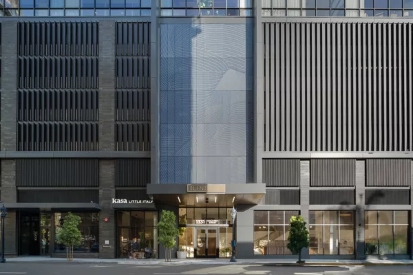 Modern high-rise entrance with textured facade and signage