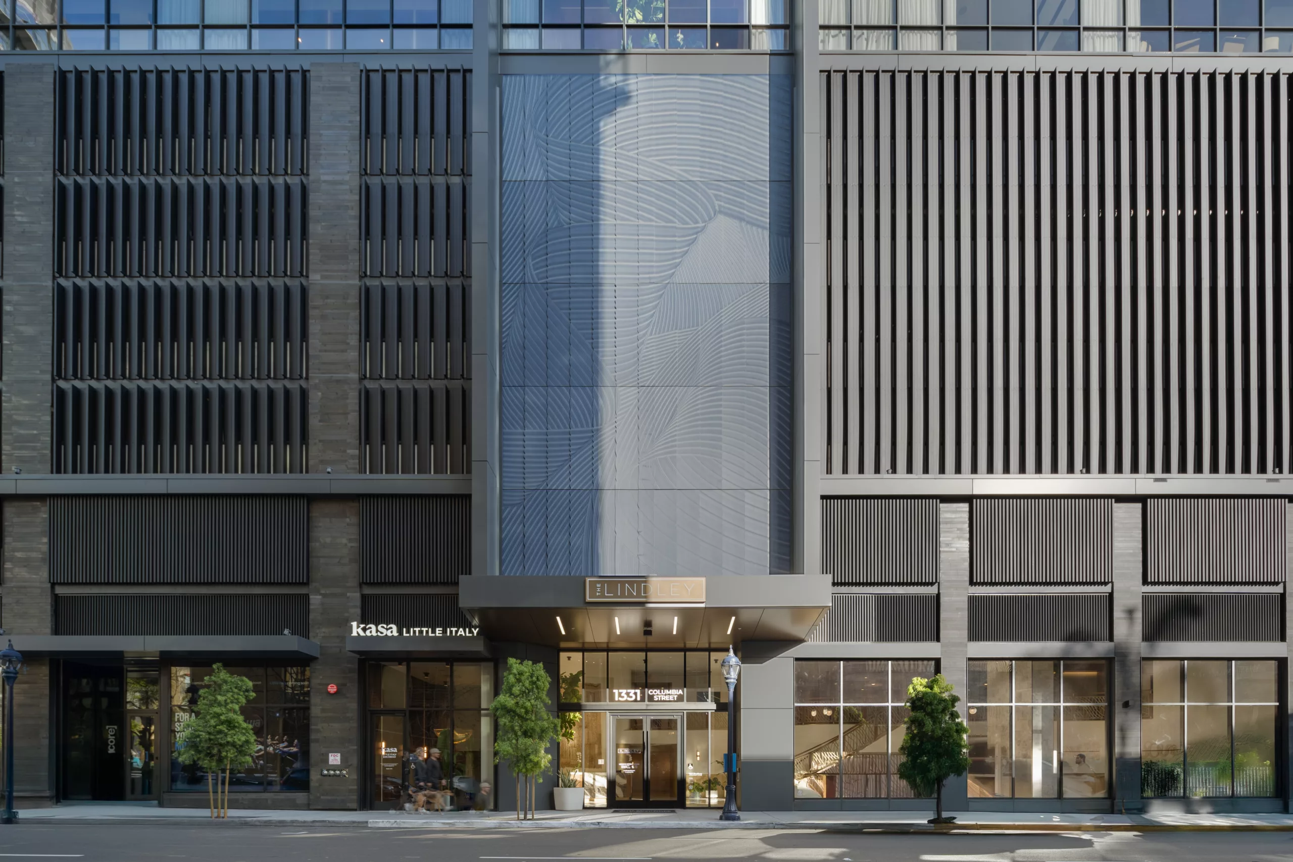 Modern high-rise entrance with textured facade and signage