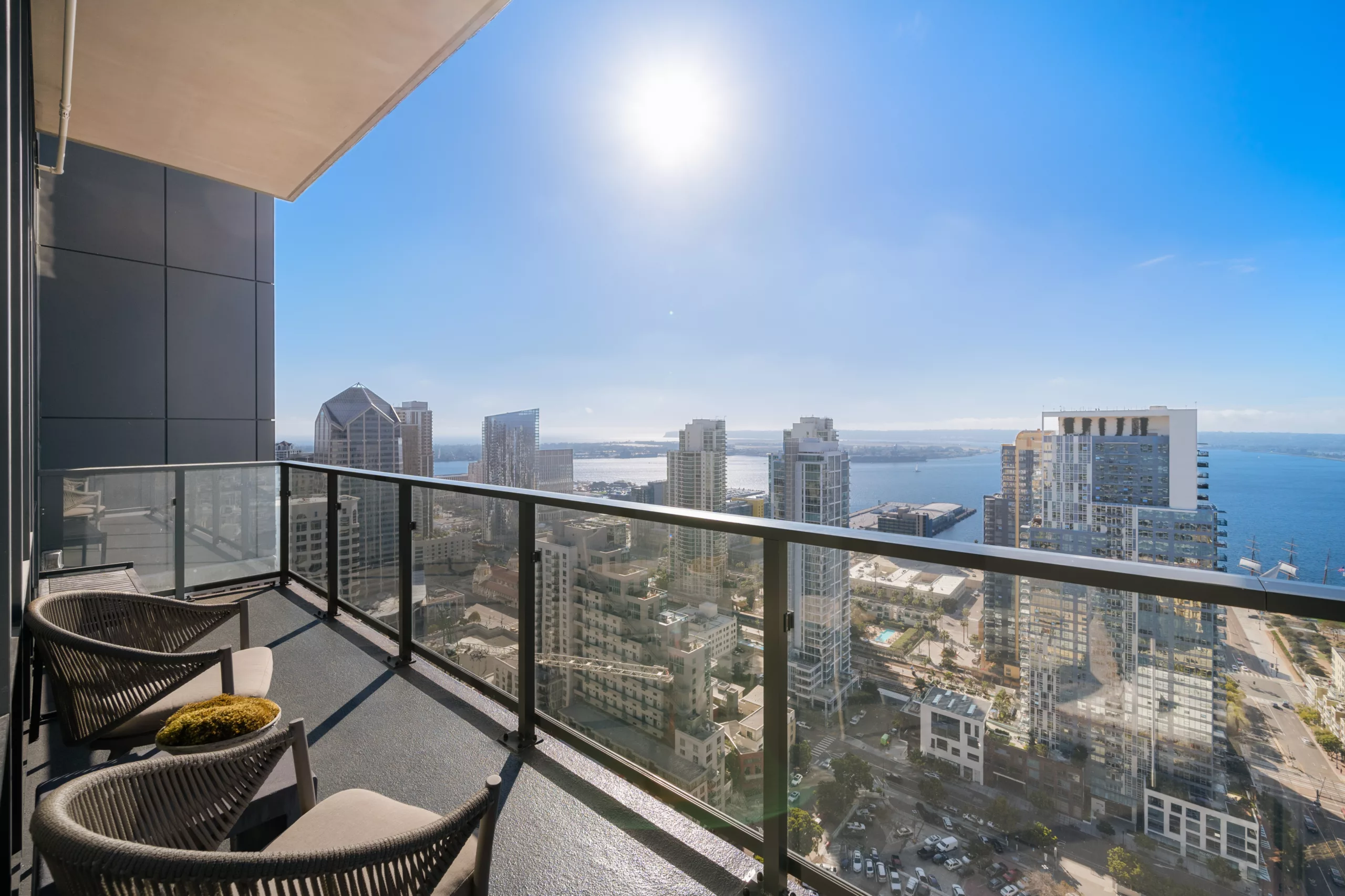 Balcony view of city skyline and ocean under bright sun