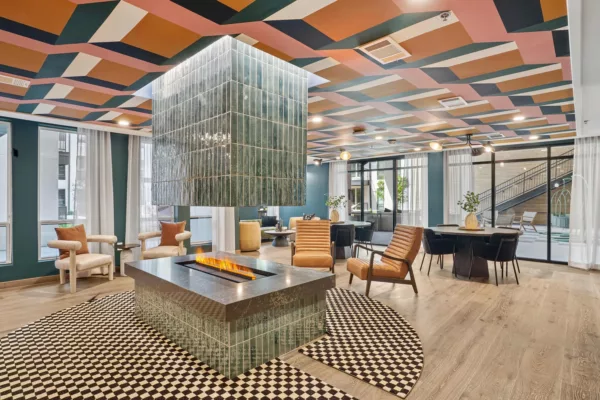 Lounge with central fireplace and colorful geometric ceiling.