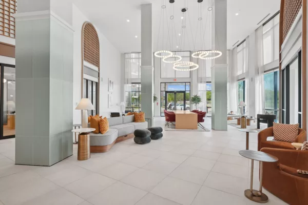 Bright modern lobby with circular chandeliers and soft seating.