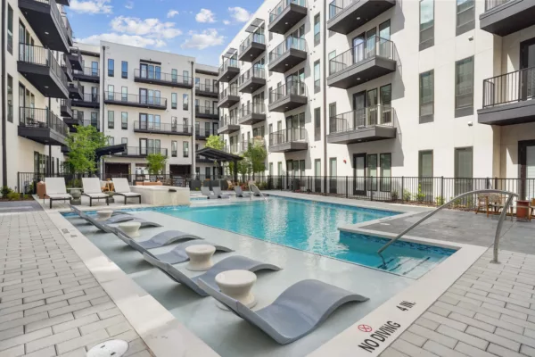 Outdoor pool courtyard with lounge chairs and in-water seating.