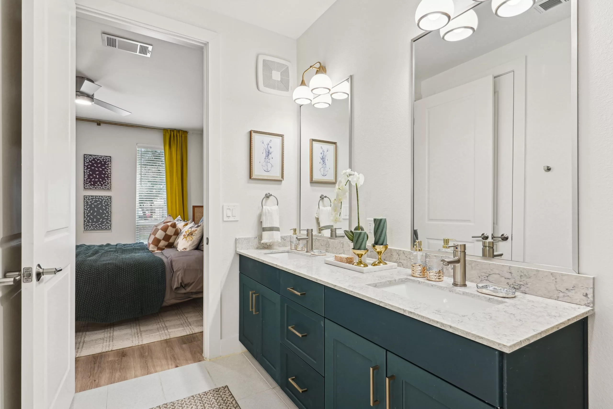 Double-sink vanity bathroom with view into bedroom.