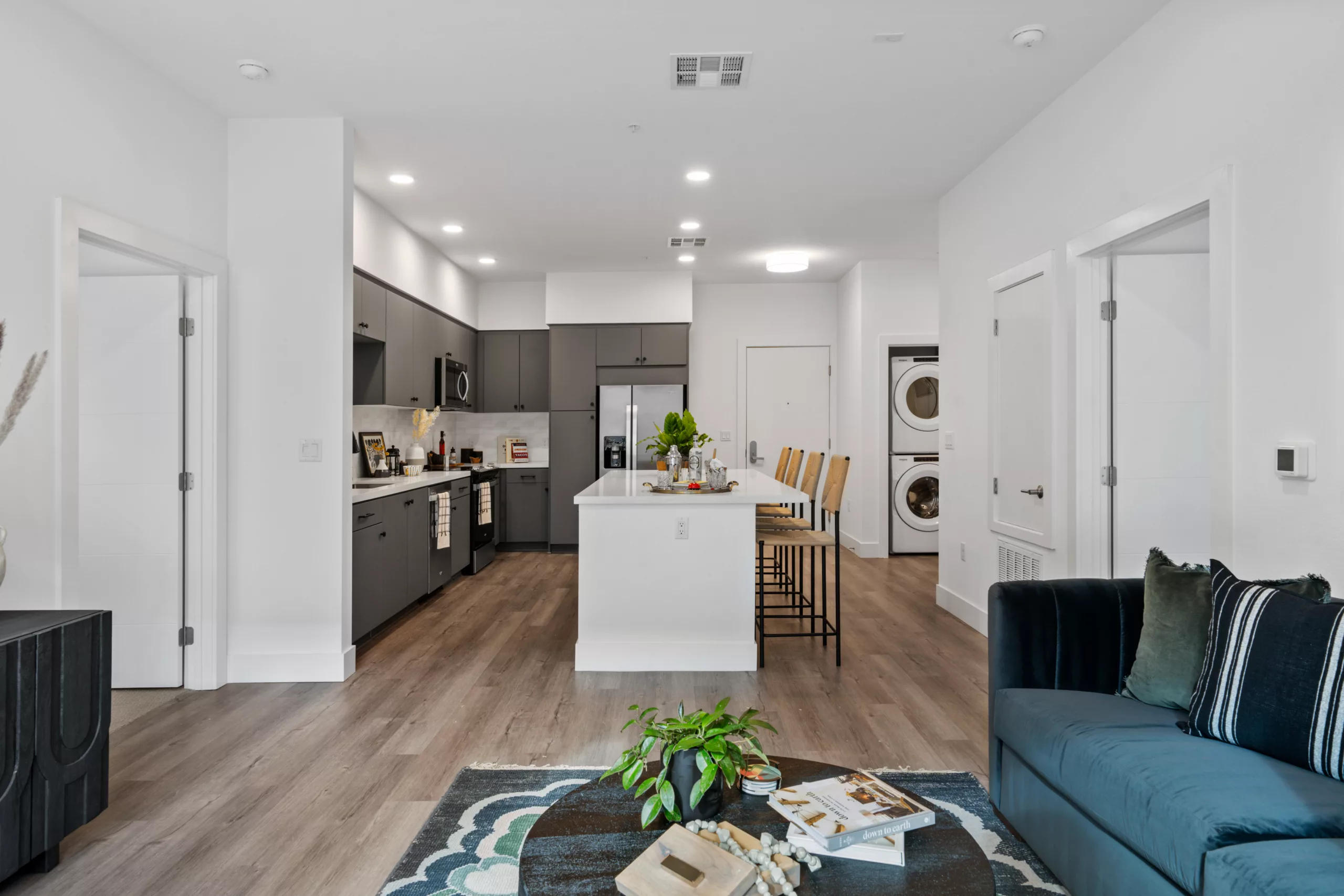 Kitchen with gray cabinets, island seating, and in-unit laundry.