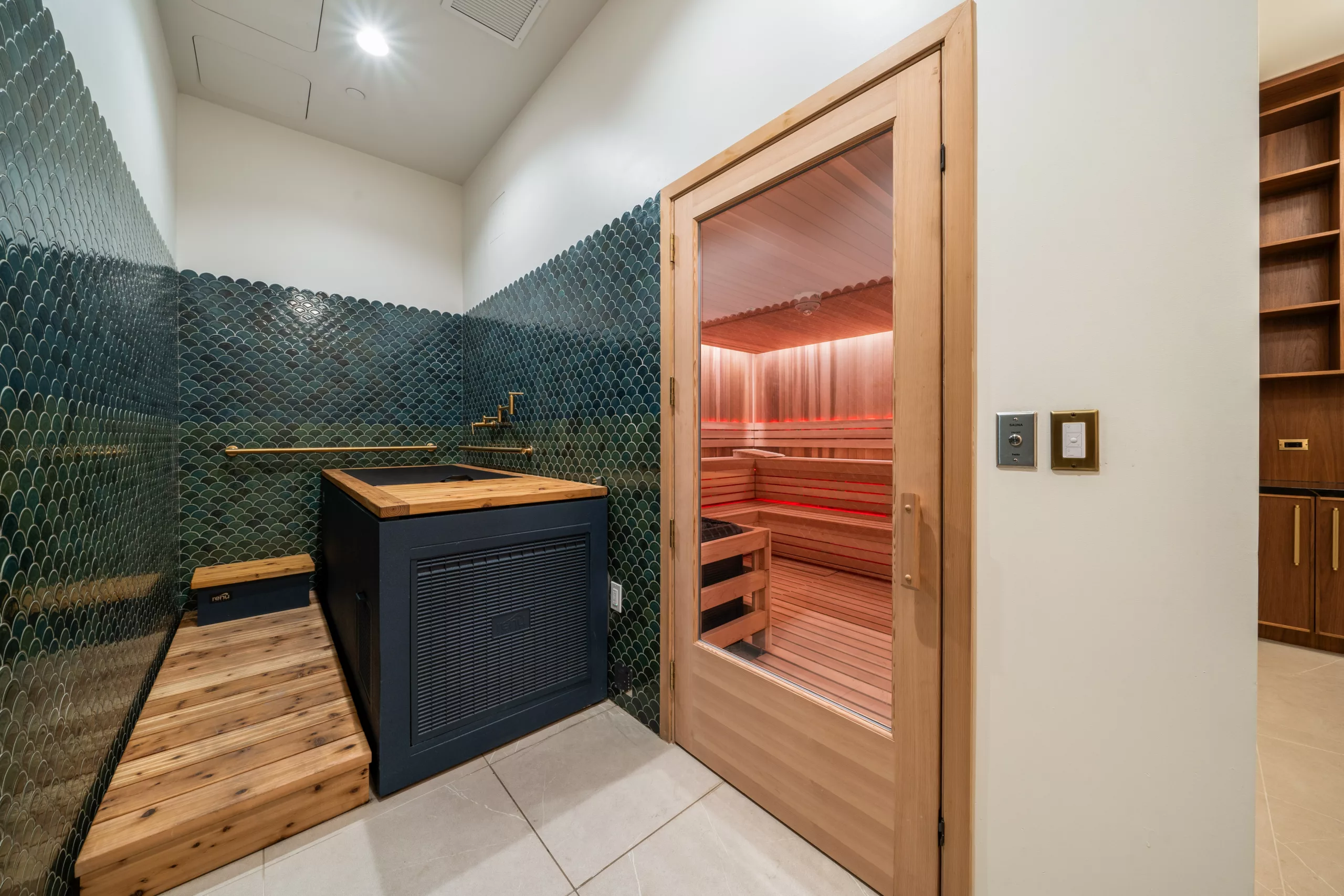 Wellness room with cold plunge tub and glass-door sauna