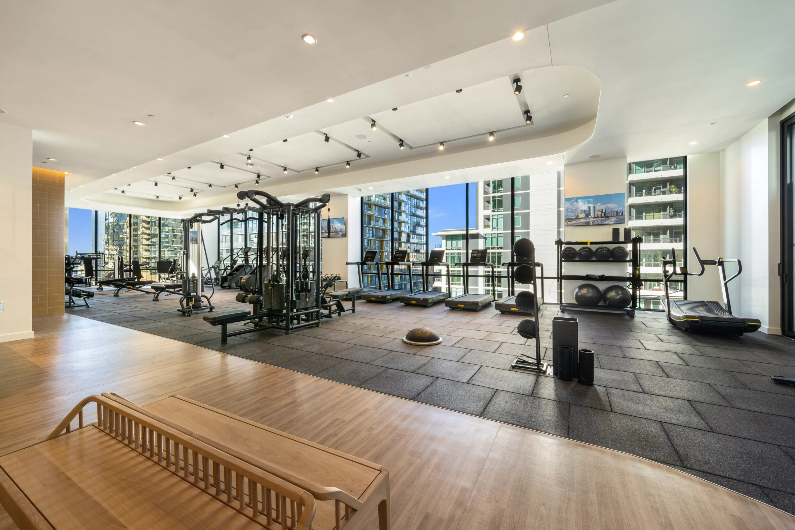 Spacious gym with large windows and variety of workout equipment