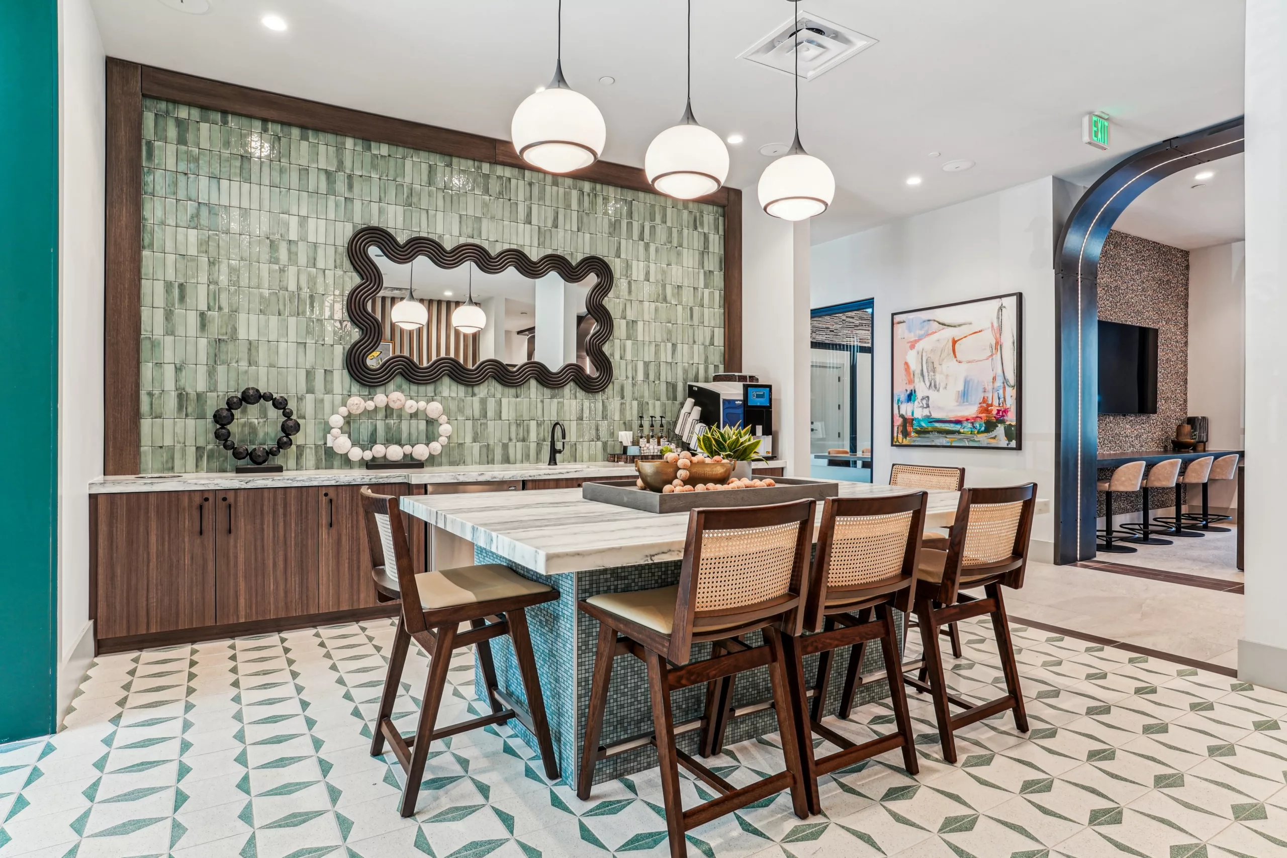 Modern kitchen lounge with island seating and green tile wall