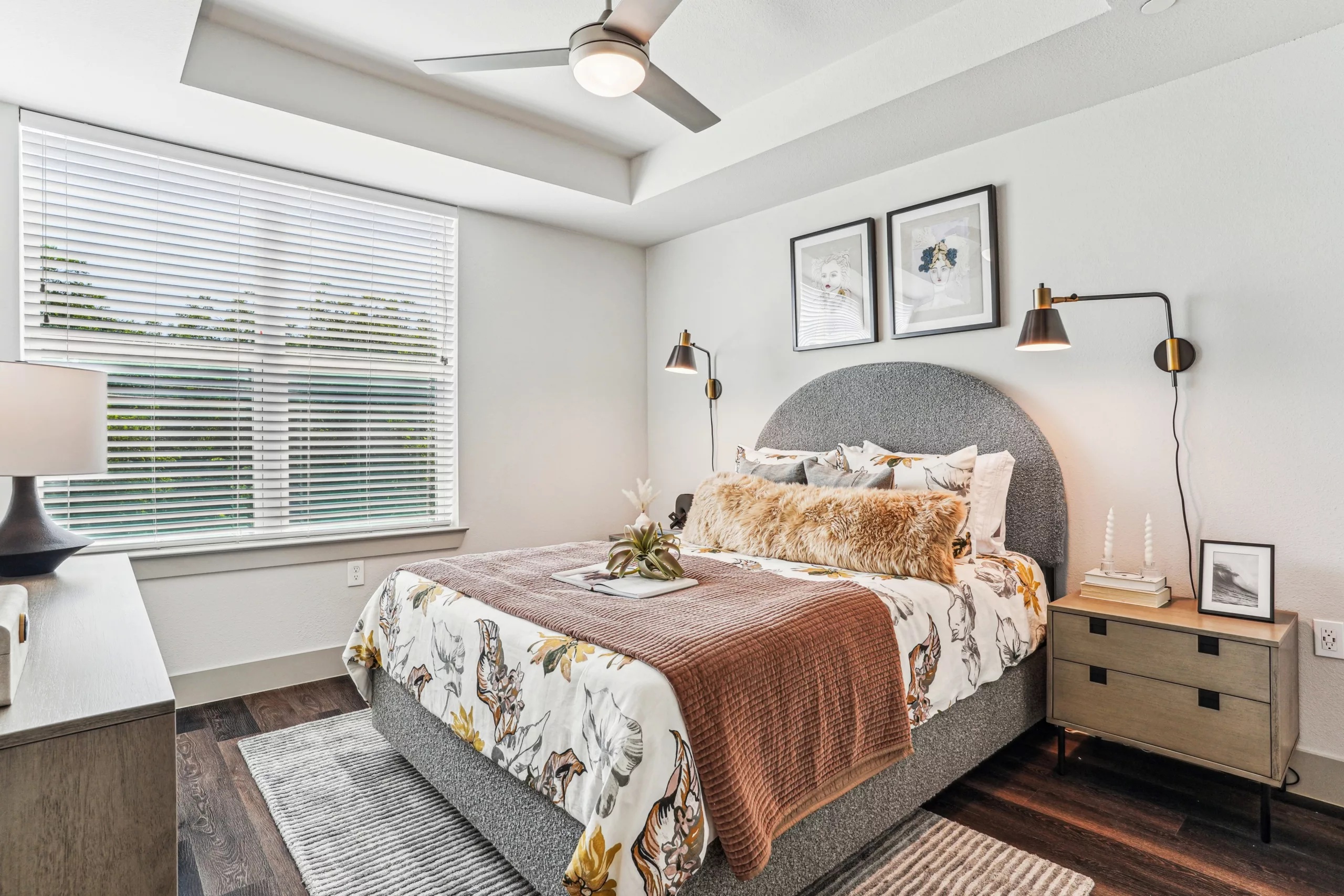 Bedroom with large window, upholstered bed, and wall art