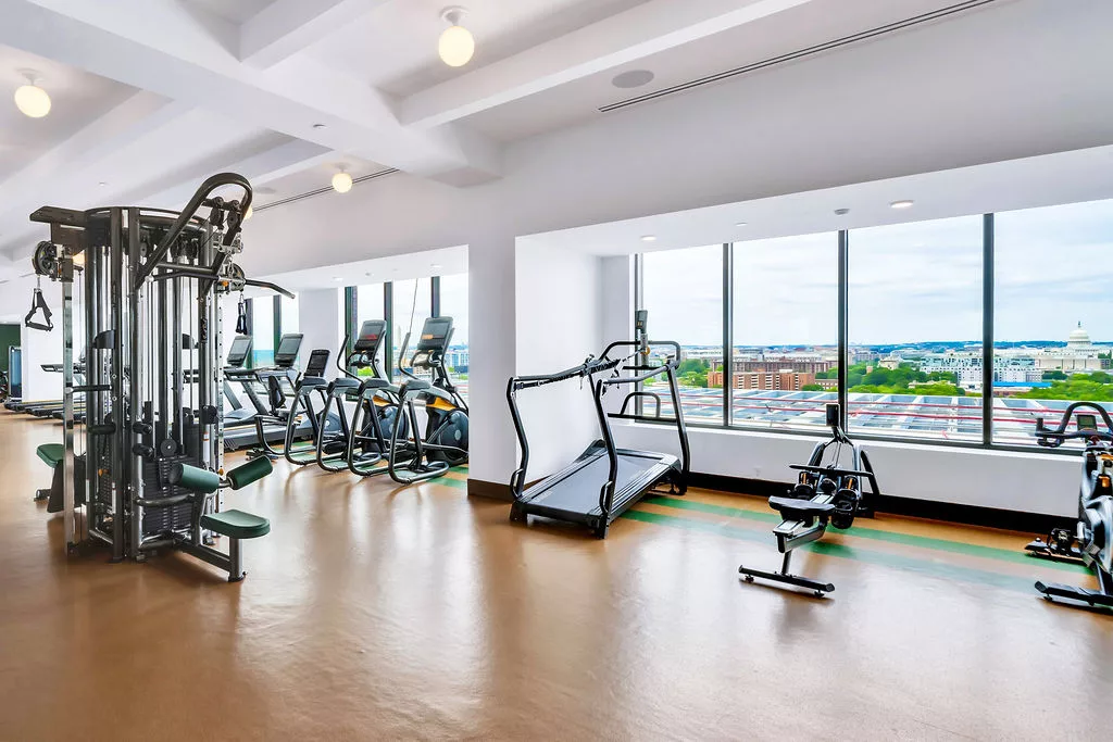 Fitness center with cardio and strength equipment and large city-view windows