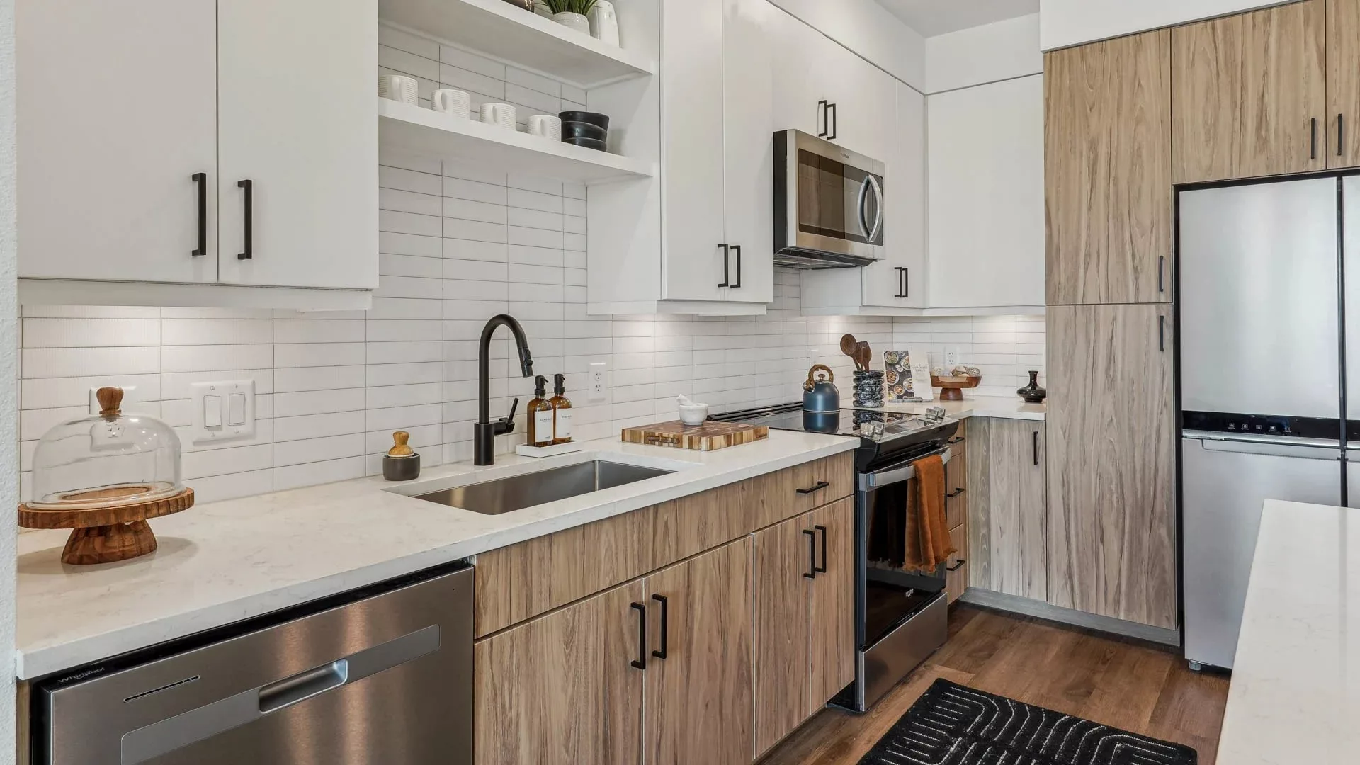 Modern kitchen with wood cabinets, white tile backsplash, and stainless appliances