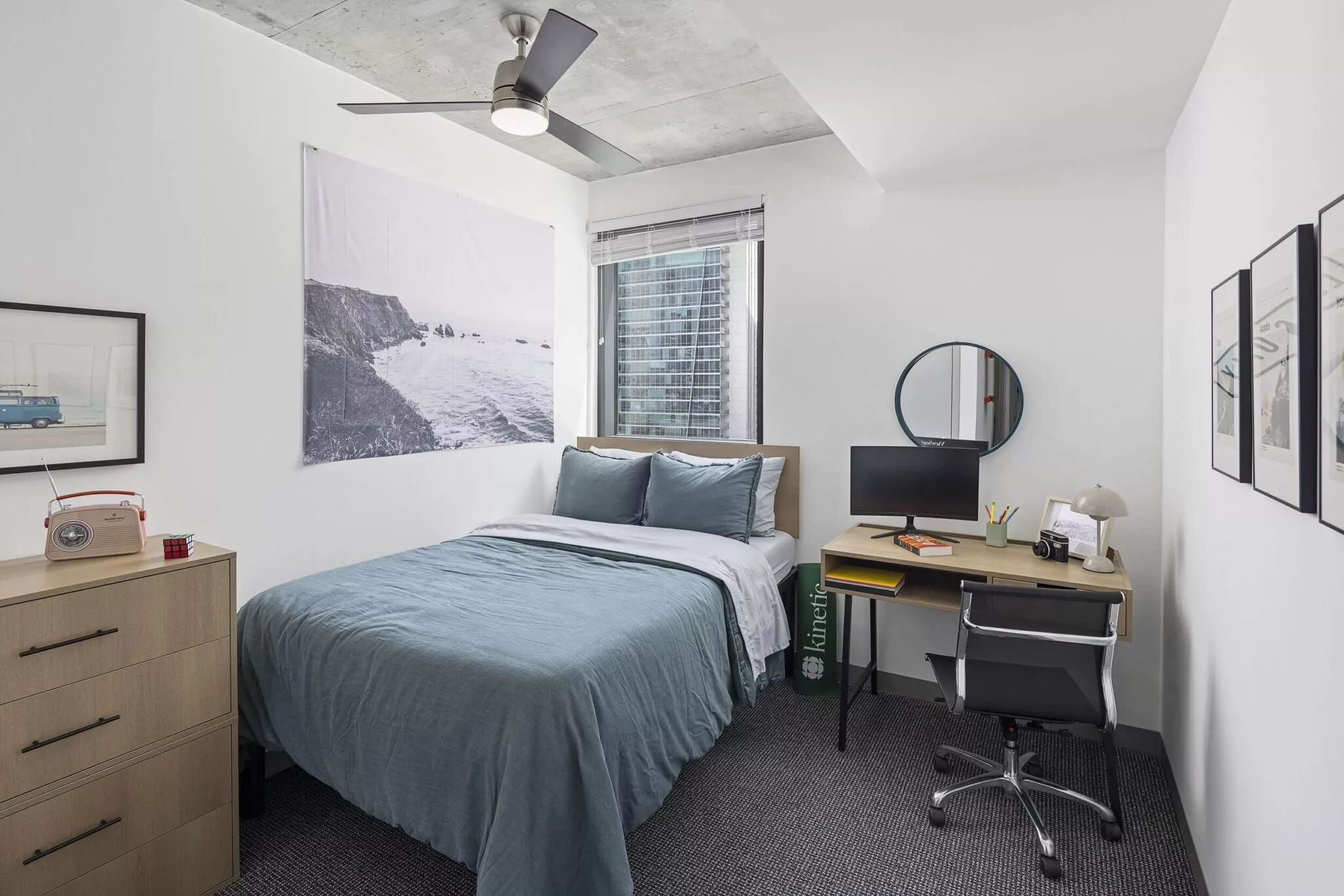 Compact bedroom with a single bed, desk, modern decor, and a concrete ceiling featuring an overhead fan.