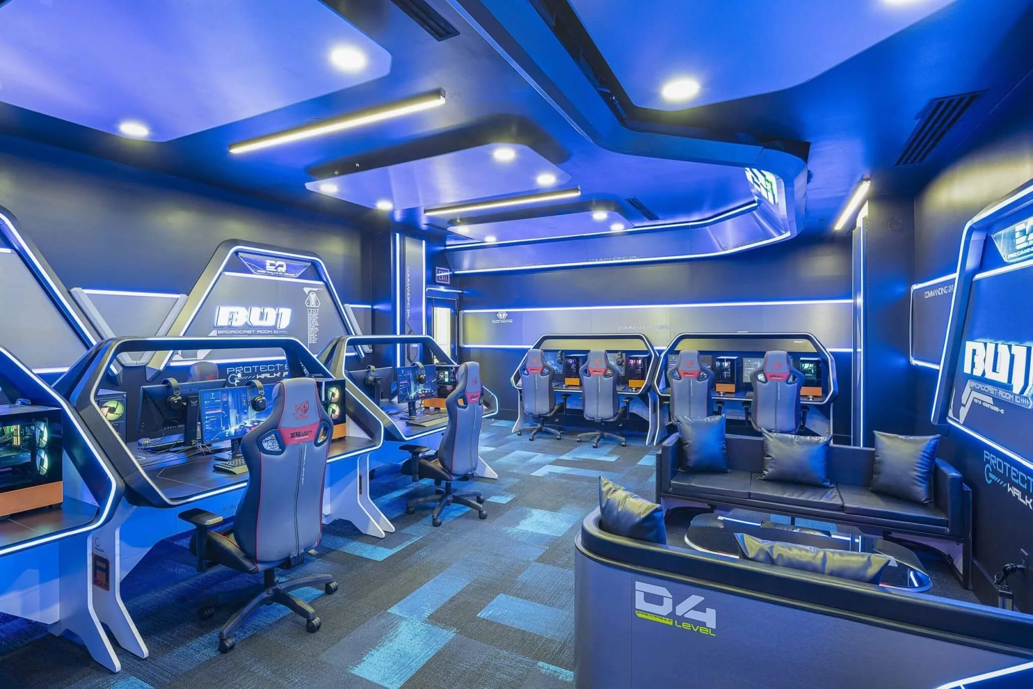 High-tech esports gaming lounge with futuristic desks, LED lighting, gaming chairs, and multiple computer stations.