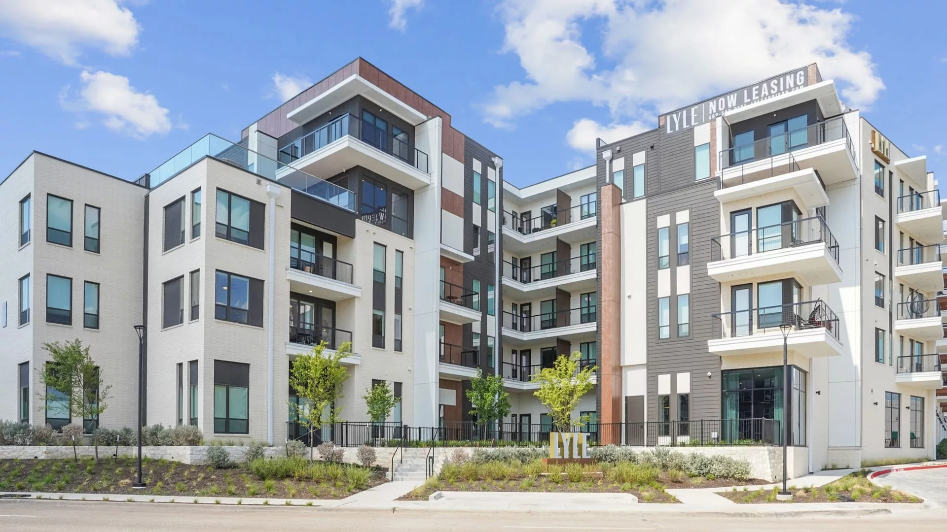 Contemporary apartment building with balconies and “LYLE Now Leasing” sign