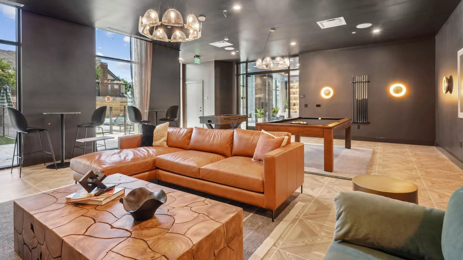 Lounge with leather sectional, pool table, and dark modern decor