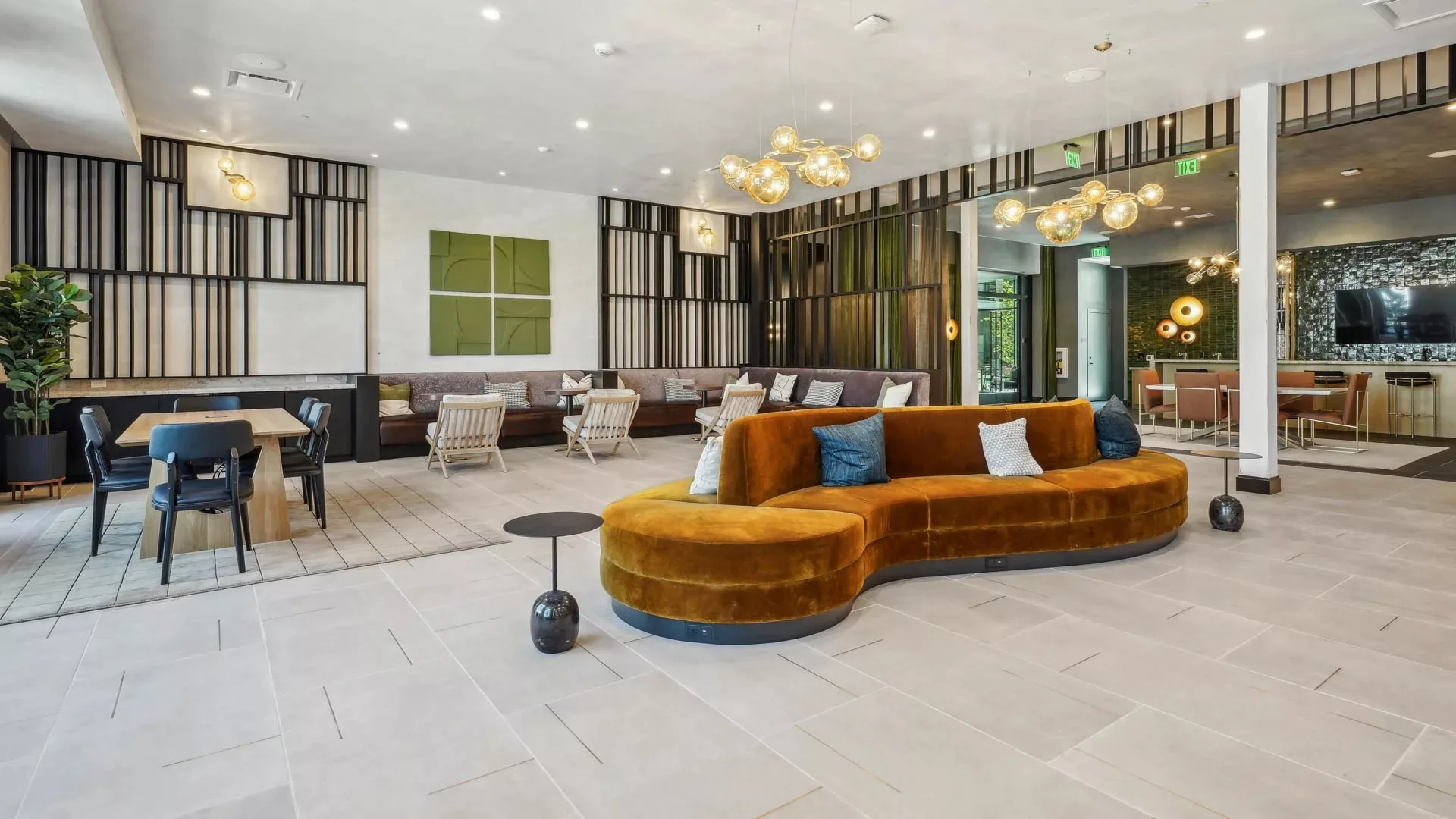 Open lounge with curved orange sofa and casual seating areas