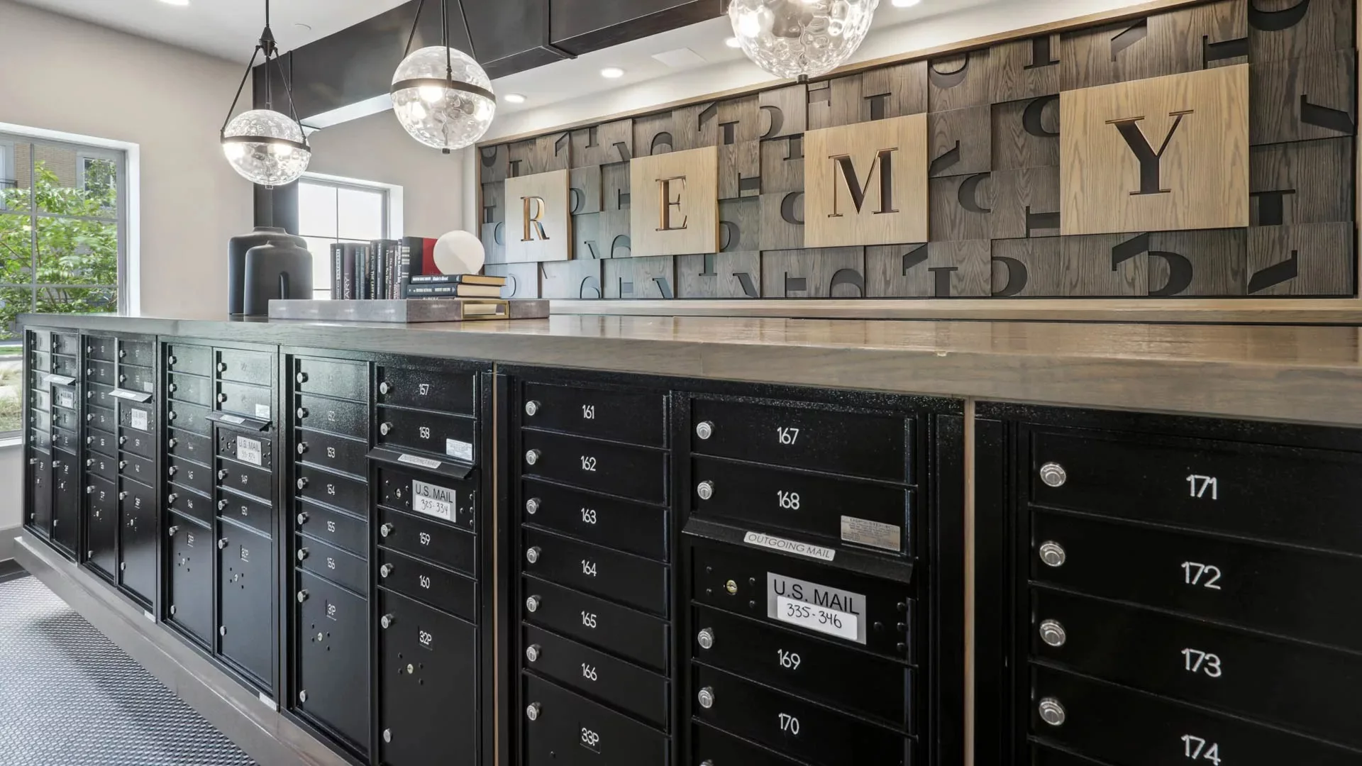Mailroom with black mailboxes and large wall art spelling “REMY”