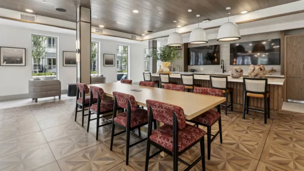 Clubroom with dining table, bar seating, and large TVs on wood-paneled wall