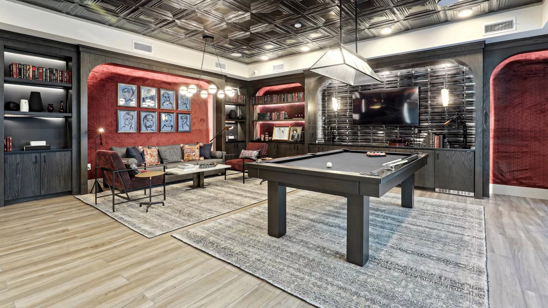 Game room with pool table, TV, bookshelves, and modern lounge seating