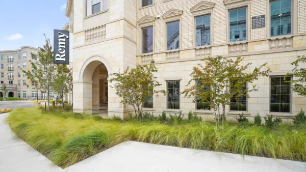 Exterior of Remy building with stone façade and landscaped walkway
