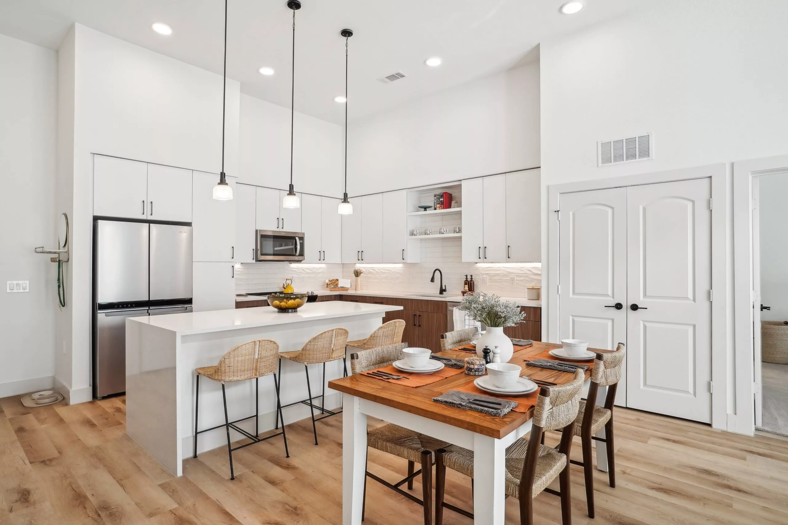 Modern kitchen with island, pendant lights, and white cabinetry