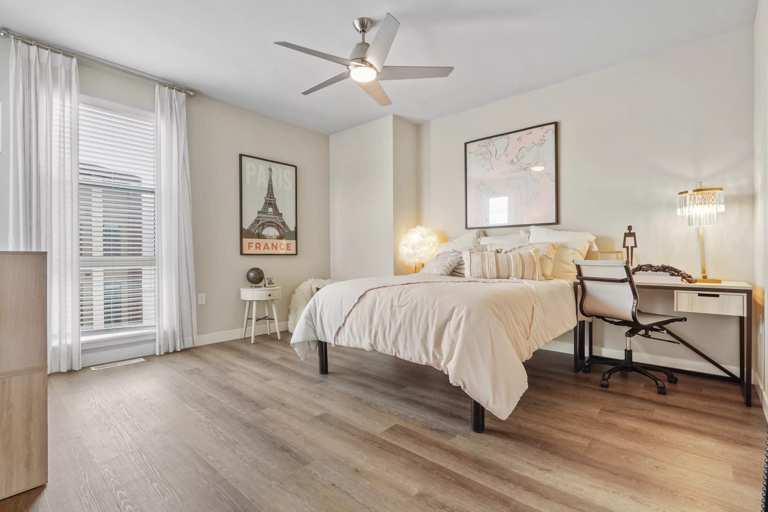 Bedroom with desk, large windows, and Eiffel Tower decor