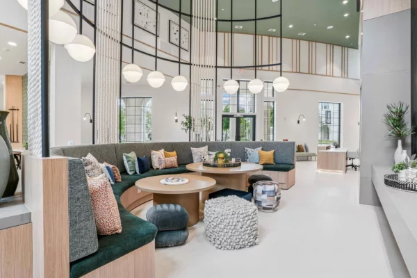 Clubroom with curved seating, round tables, and decorative lighting fixtures.