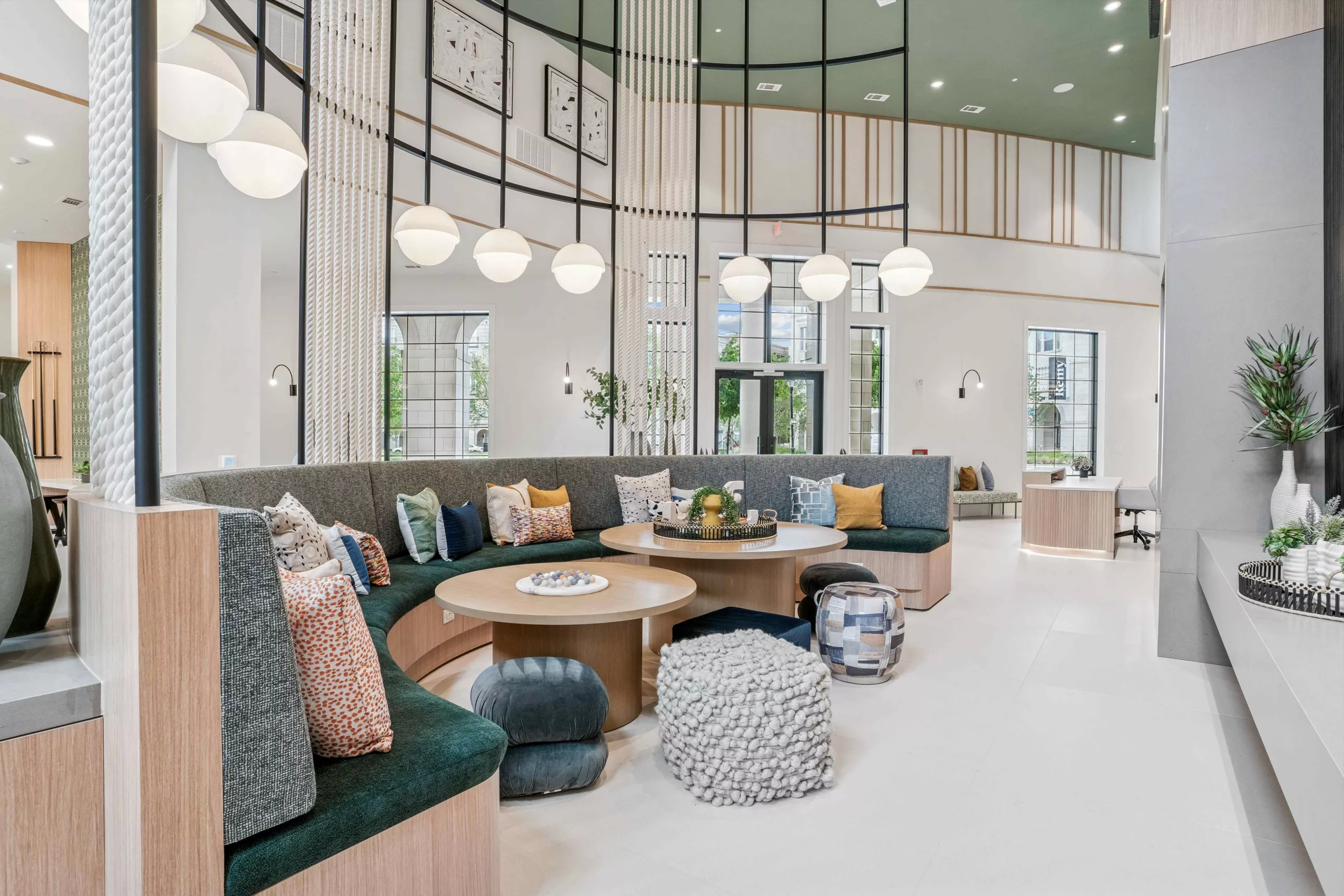 Clubroom with curved seating, round tables, and decorative lighting fixtures.