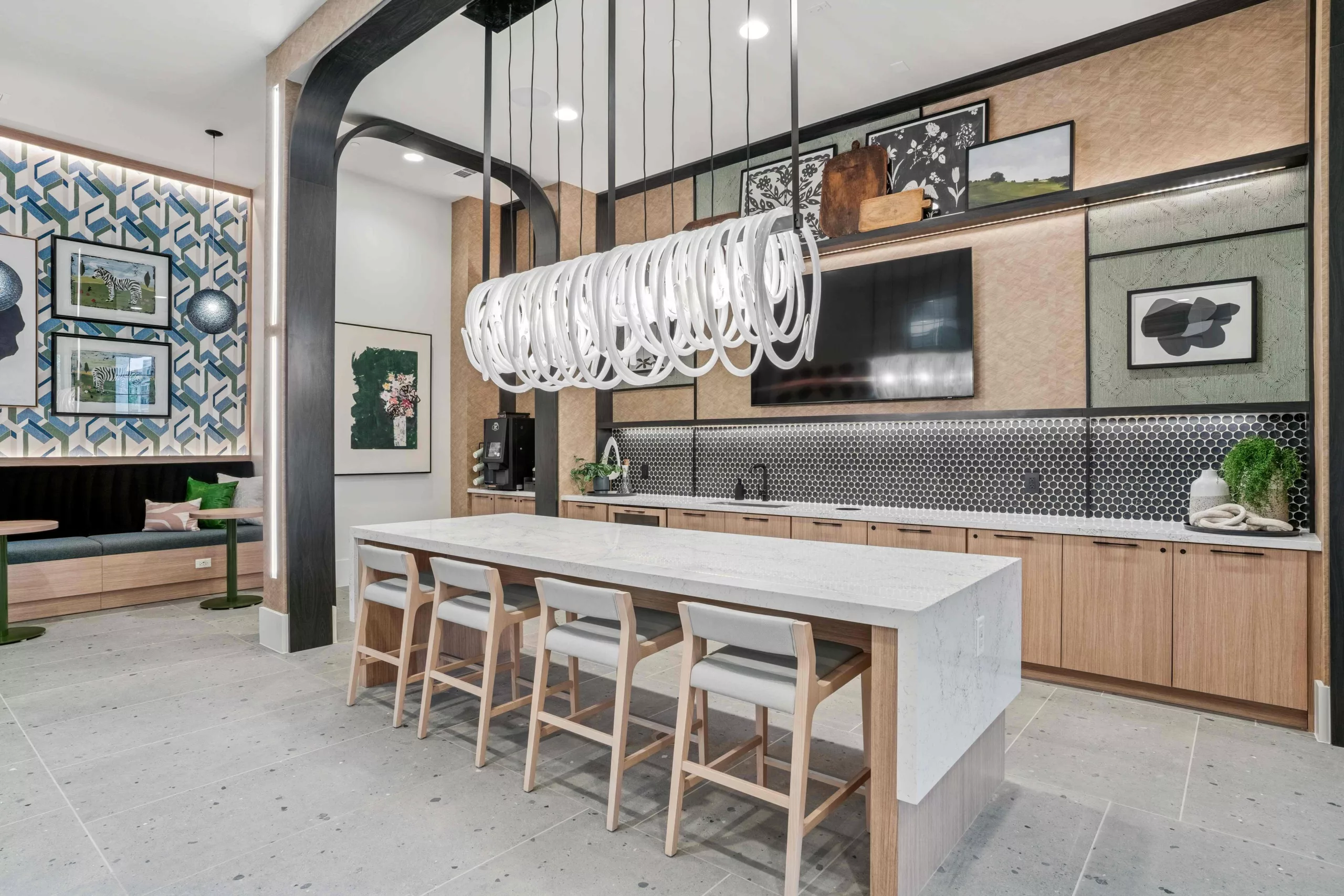 Resident bar lounge with island, seating, coffee bar, and bespoke hanging lights.