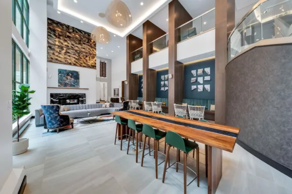 Grand lobby with high ceilings, seating, and a long wooden table with green chairs.