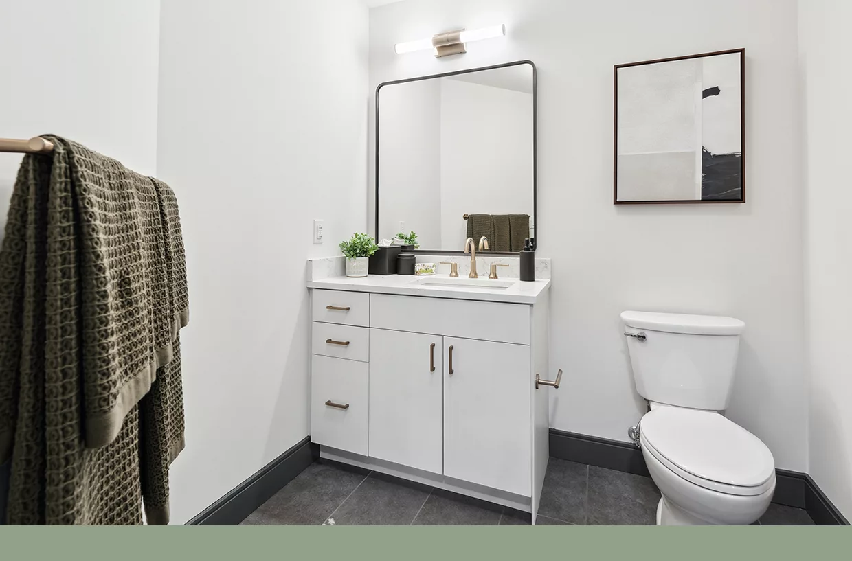 Modern bathroom with white vanity, large mirror, and neutral-toned decor accents.