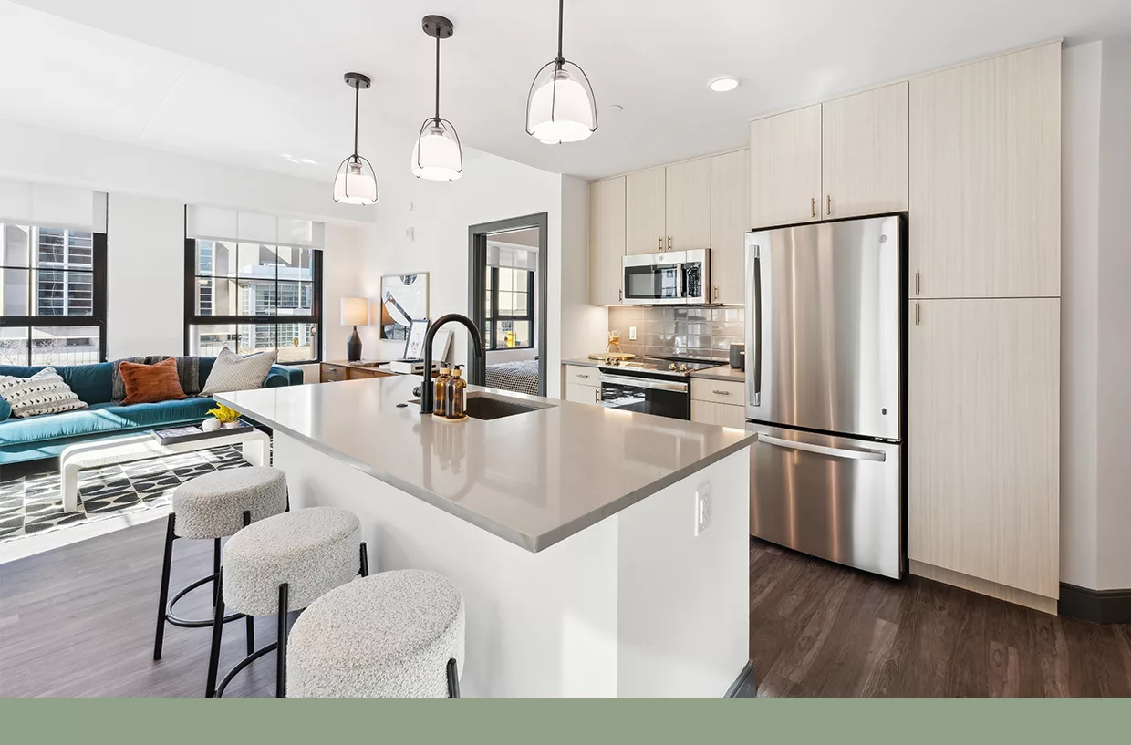 Modern kitchen with island, stainless steel appliances, and open living area.