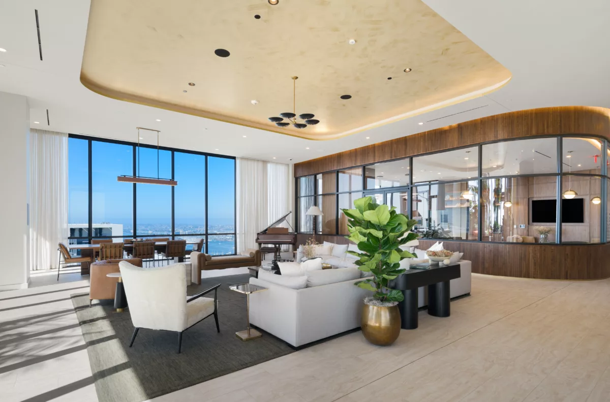 Modern sky lounge with floor-to-ceiling windows, elegant seating, piano, and panoramic city view.